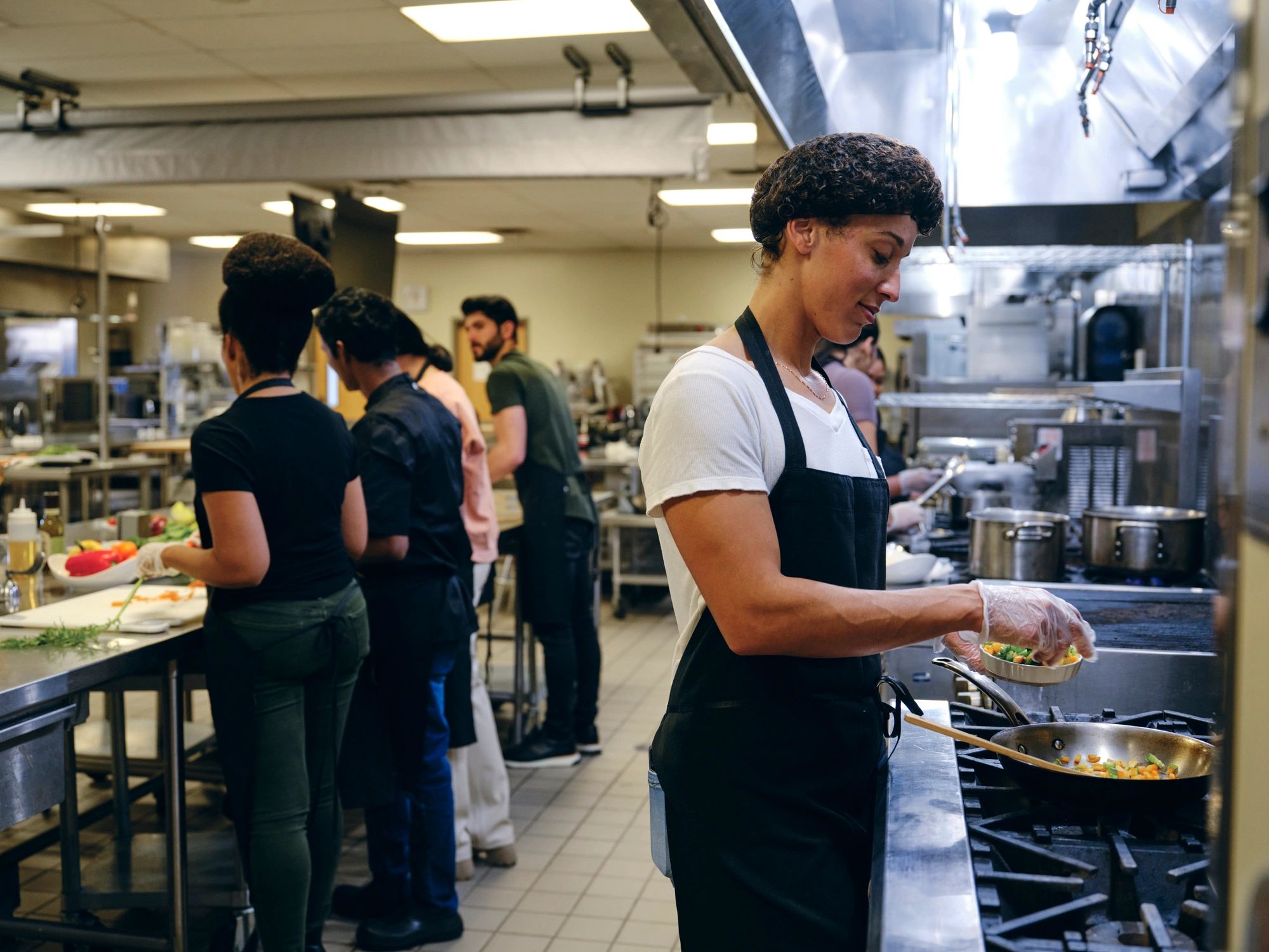 Student baker working confidently in a professional kitchen